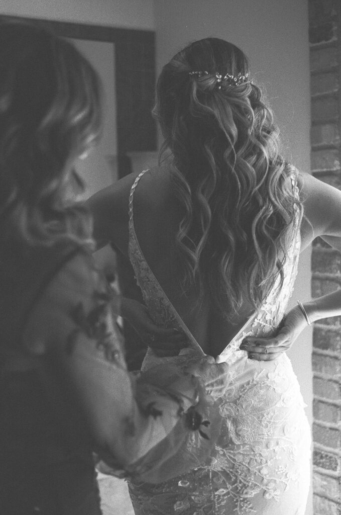 Bride gets zipped into her dress on her wedding day