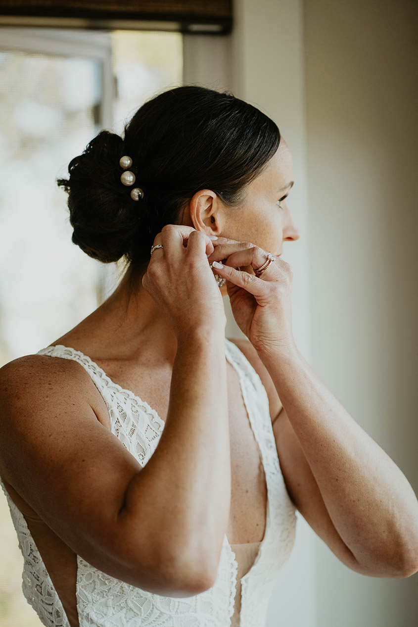 The bride putting on earrings. 
