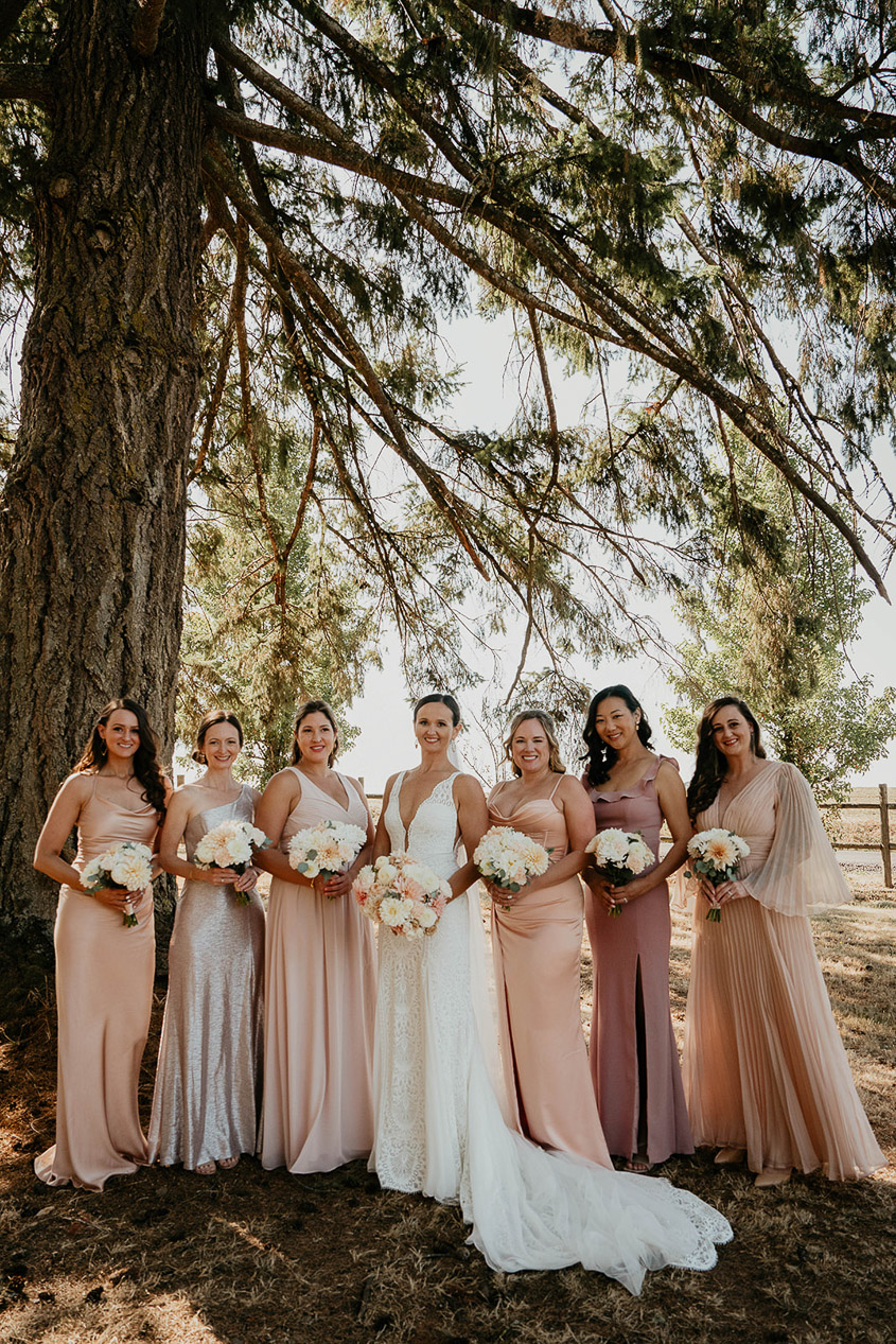 The bride with her wedding party under a tree. 