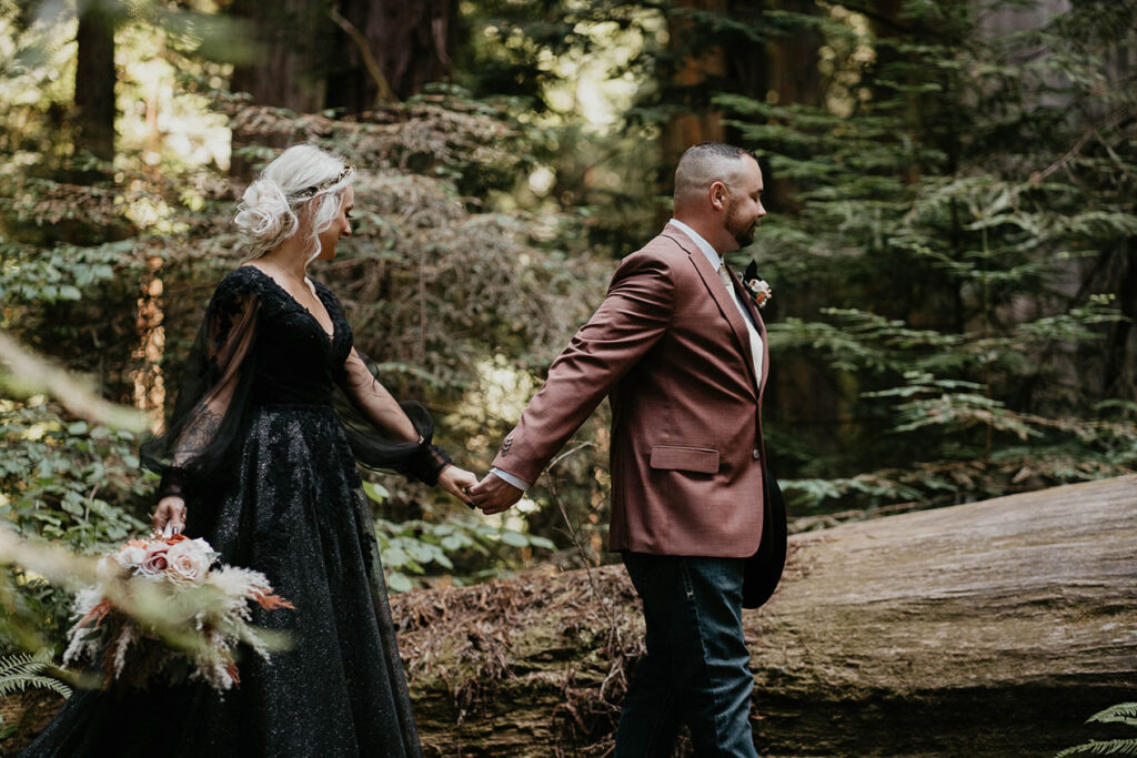 The husband guiding his wife through the forest during their Redwoods Elopement. 