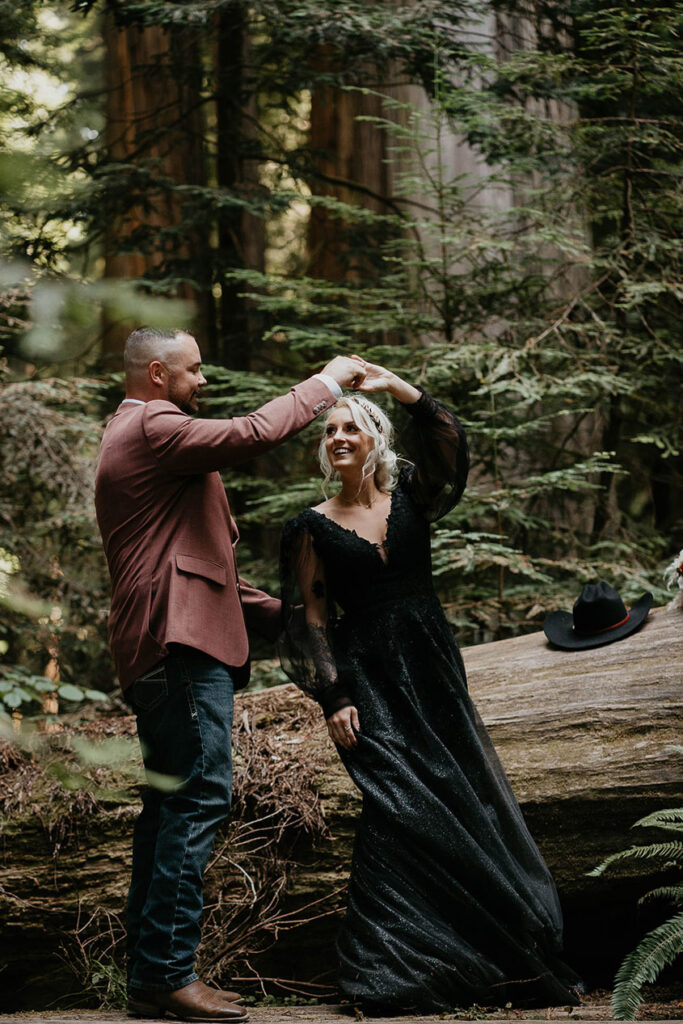The husband twirling his wife in the forest during their Redwoods Elopement. 