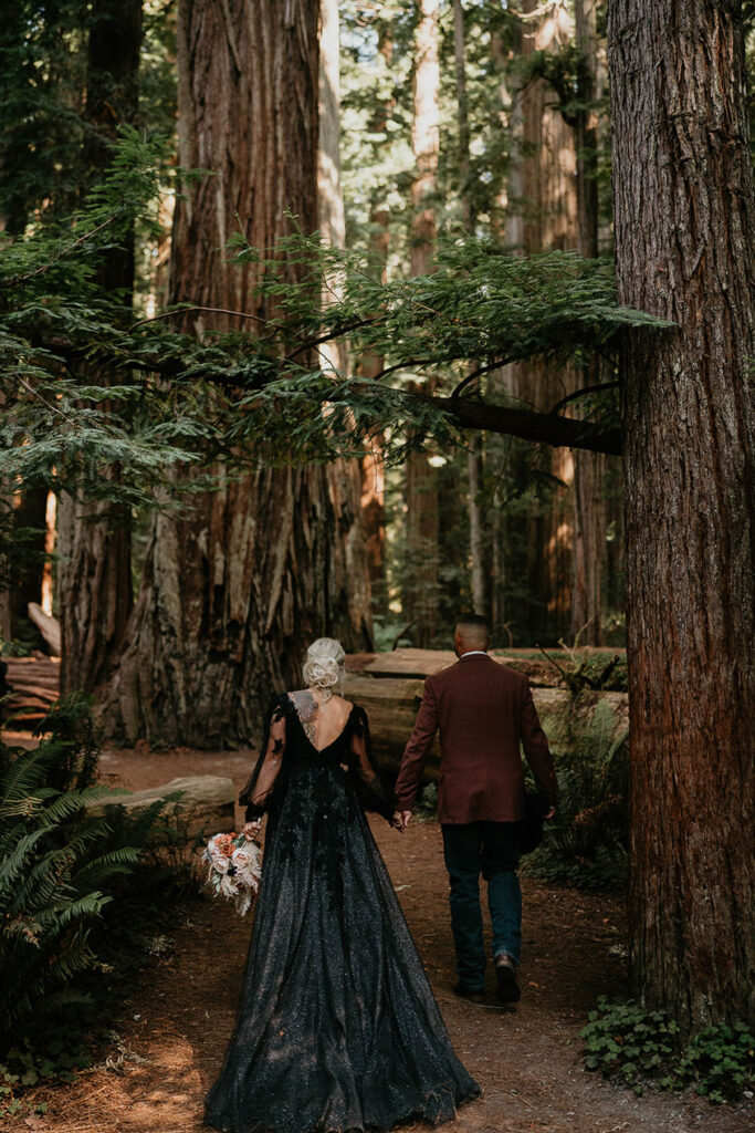 the newlyweds walking through a redwood forest during their elopement. 