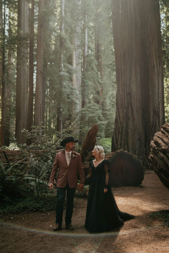 The couple holding hands in the middle of the forest during the Redwoods Elopement. 