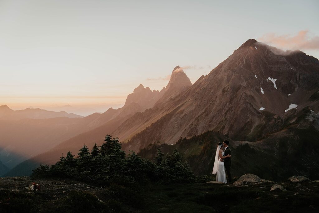 Bride and groom take photos on a mountain after they elope in Washington