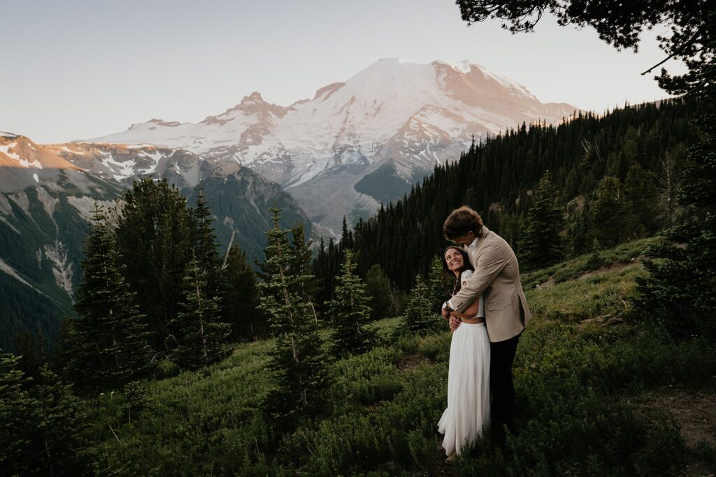 Bride and groom hug on a mountain during their Washington elopement in Mount Rainier National Park