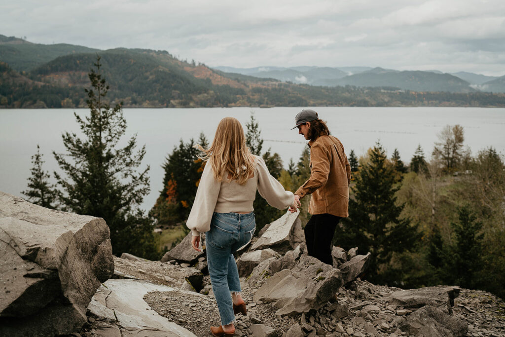 A couple holding hands and exploring the Columbia River Gorge during their engagement session. 