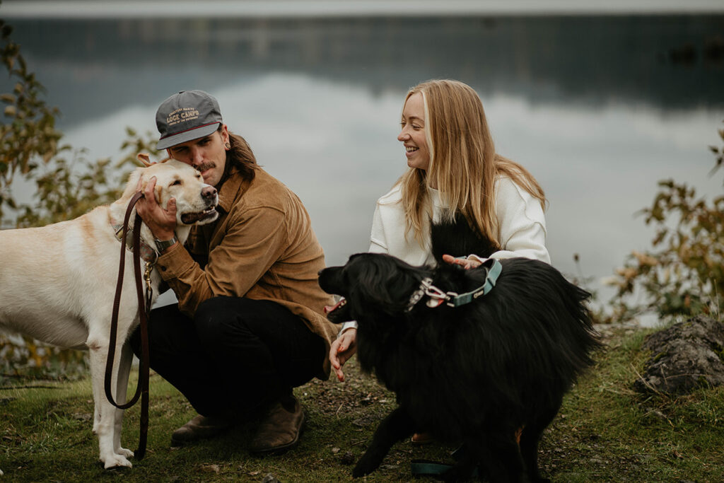 A newly engaged couple holding and embracing their dogs in the Columbia River Gorge. 