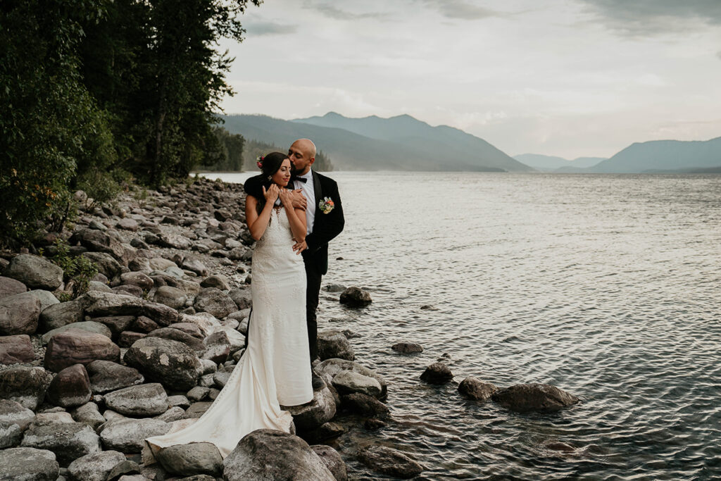 The couple embracing each other on the lake shore. 