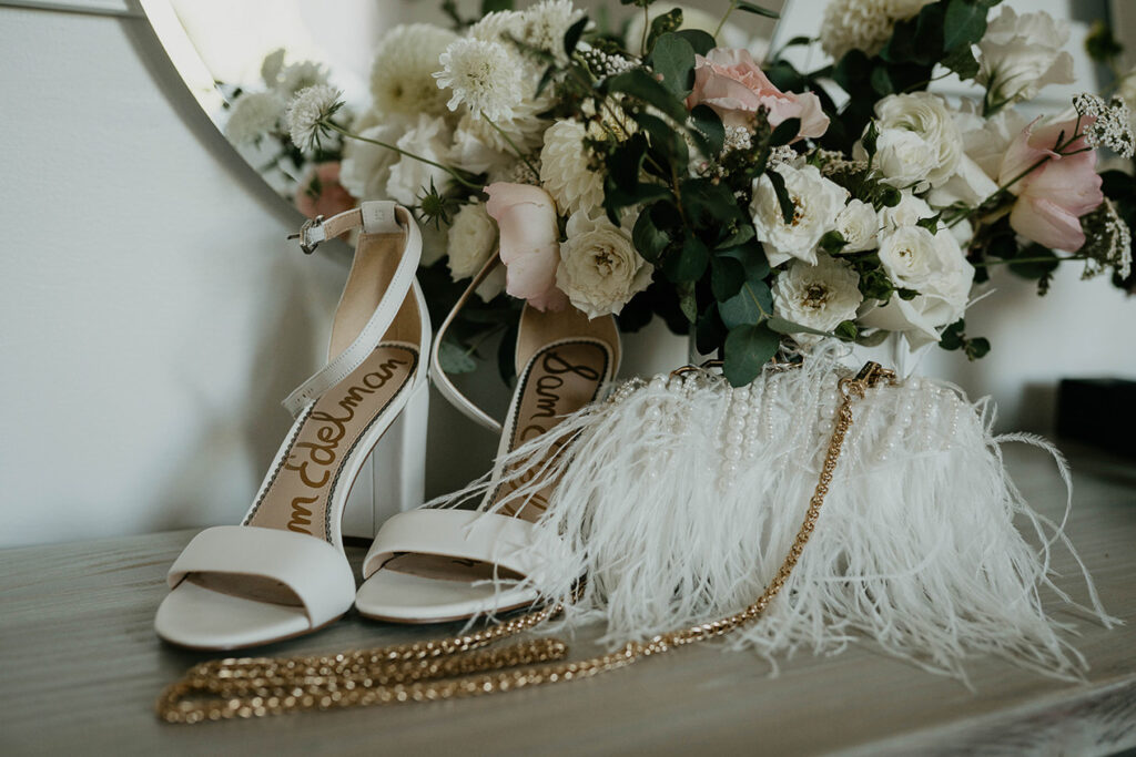 the bride's heals, hand bag, and a bouquet of flowers. 