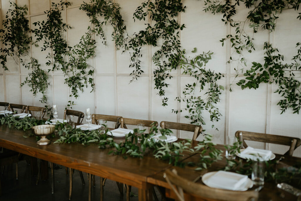The Orchard Hood River wedding table with ivy and white place settings. 