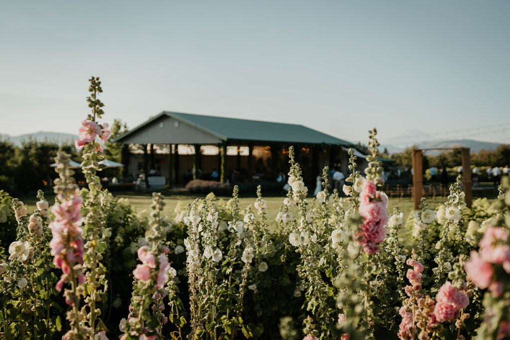 The Orchard Hood River covered venue with flowers in the foreground. 
