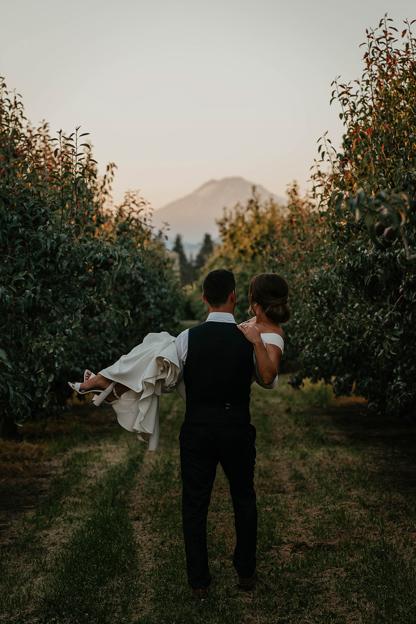 The bride being carried by the groom at The Orchard Hood River.