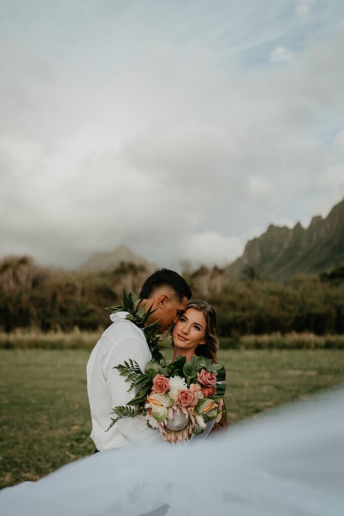 Groom kisses bride on the cheek during their Hawaii elopement photos