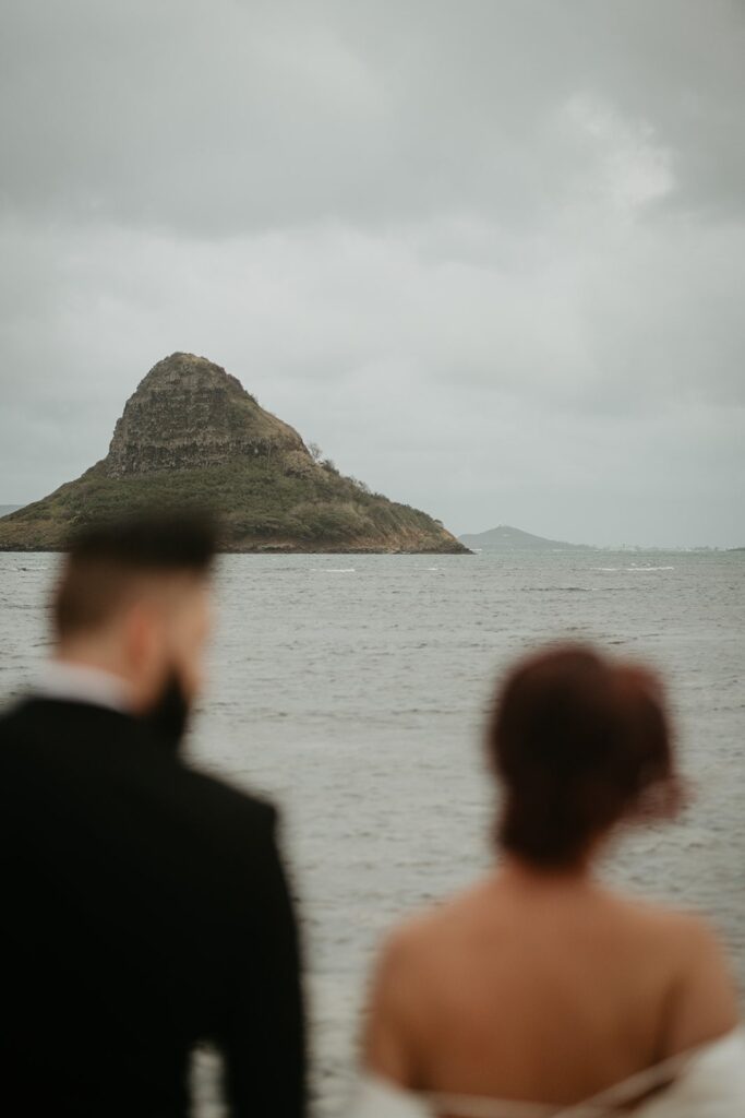 Bride and groom look out over the ocean during their Hawaii elopement