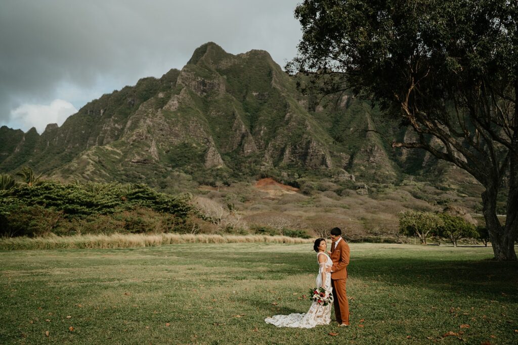 Bride and groom take wedding photos on the lawn after they elope in Hawaii
