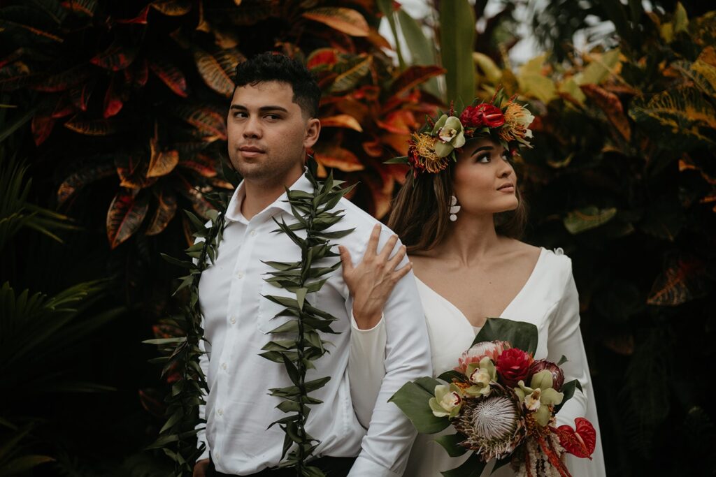 Bride and groom take photos in a rainforest after they elope in Hawaii