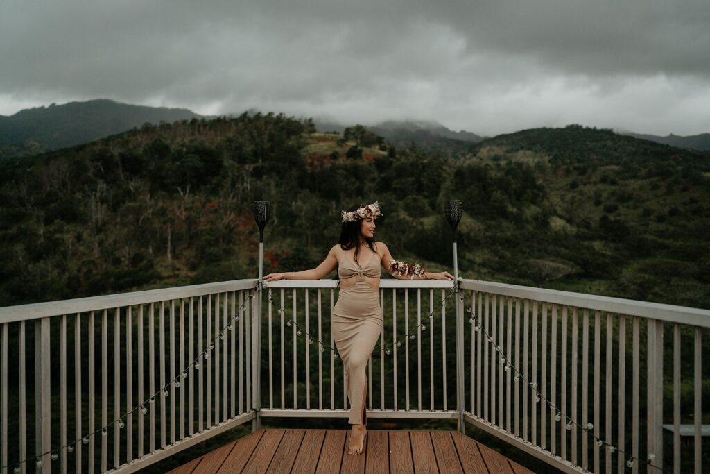 Bride stands at a lookout over a valley after she elopes in Hawaii