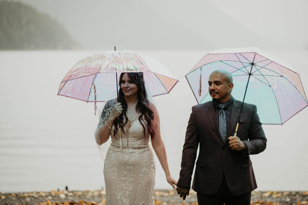The bride and groom holding hands in the rain during their Lake Crescent elopement. 