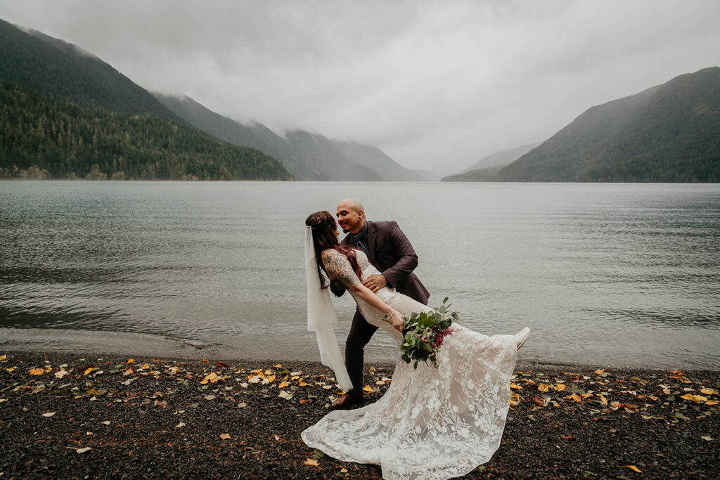 The groom tipping the bride at Lake Crescent during their elopement. 