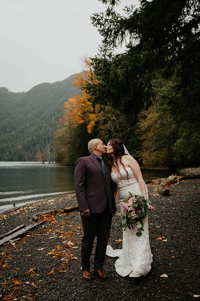 The bride and groom kissing with Lake Crescent in the background. 