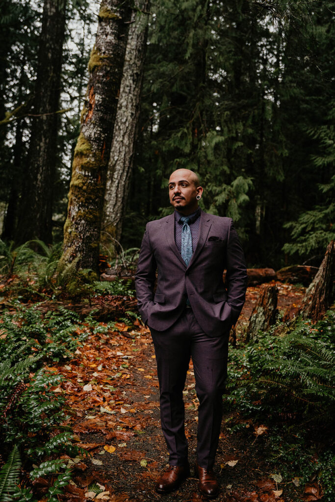 The groom posing in the forest. 