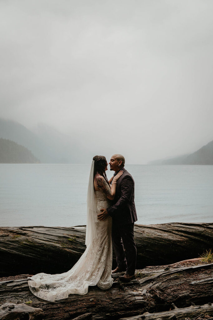 The newlyweds holding each other by Lake Crescent during their elopement. 