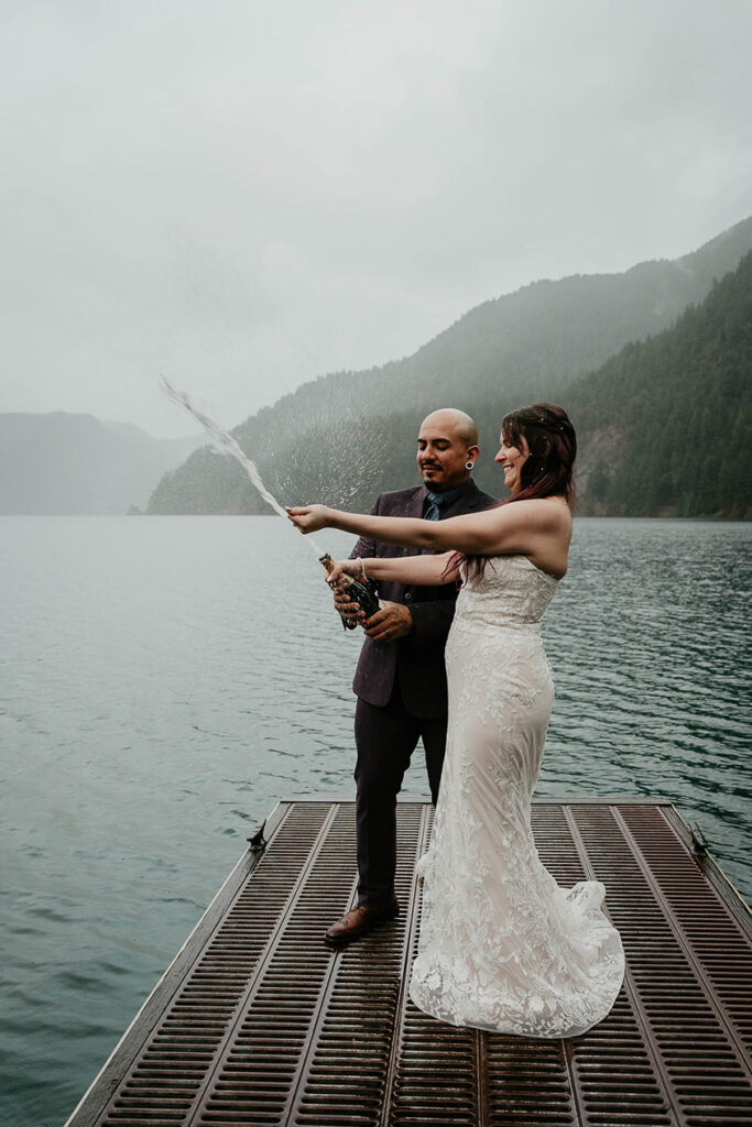 The newlyweds popping a bottle of champagne on Lake Crescent. 