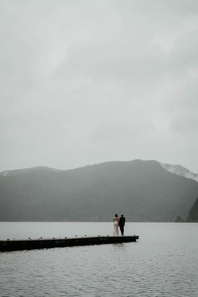The newlyweds standing on a dock on Lake Crescent. 