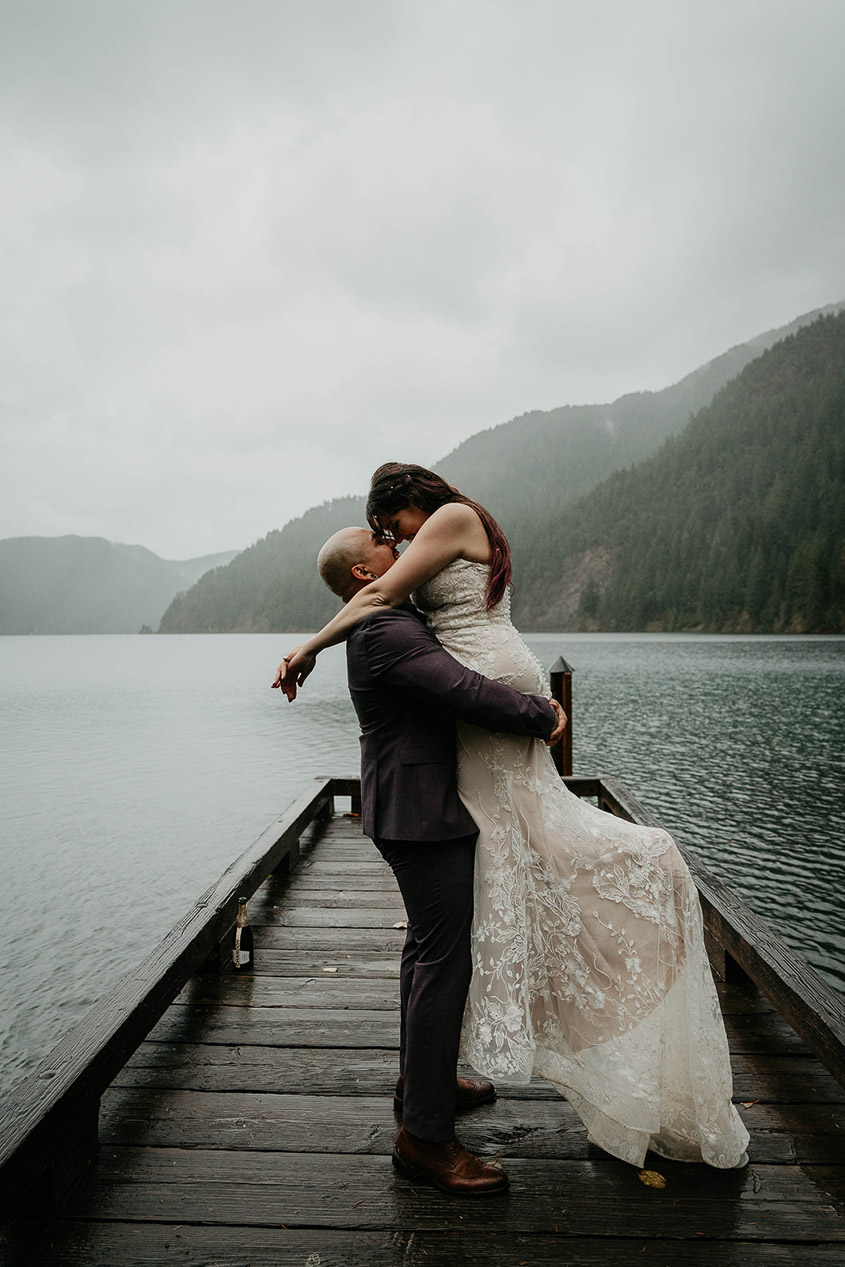 The newlyweds holding each other on a dock in Lake Crescent. 