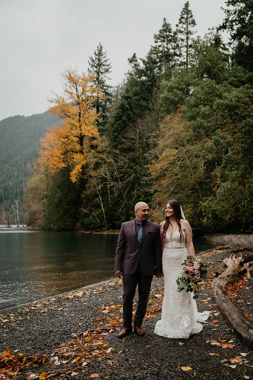 The bride and groom walking along Lake Crescent.