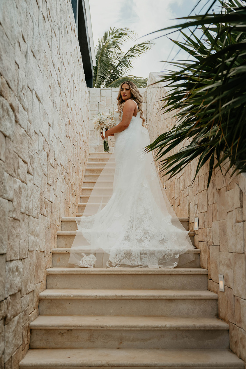the bride posing on a set of stairs during their Mexico destination wedding. 