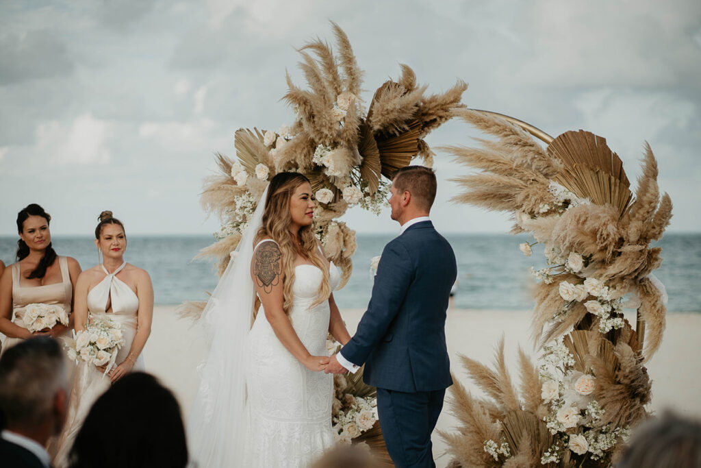 The bride and groom at the altar on a beach during their Mexico destination wedding. 