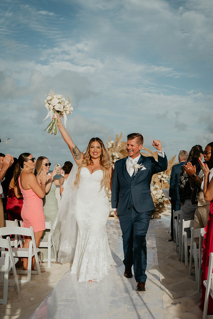 The newlyweds walking down the isle together after their ceremony at their Mexico destination wedding. 