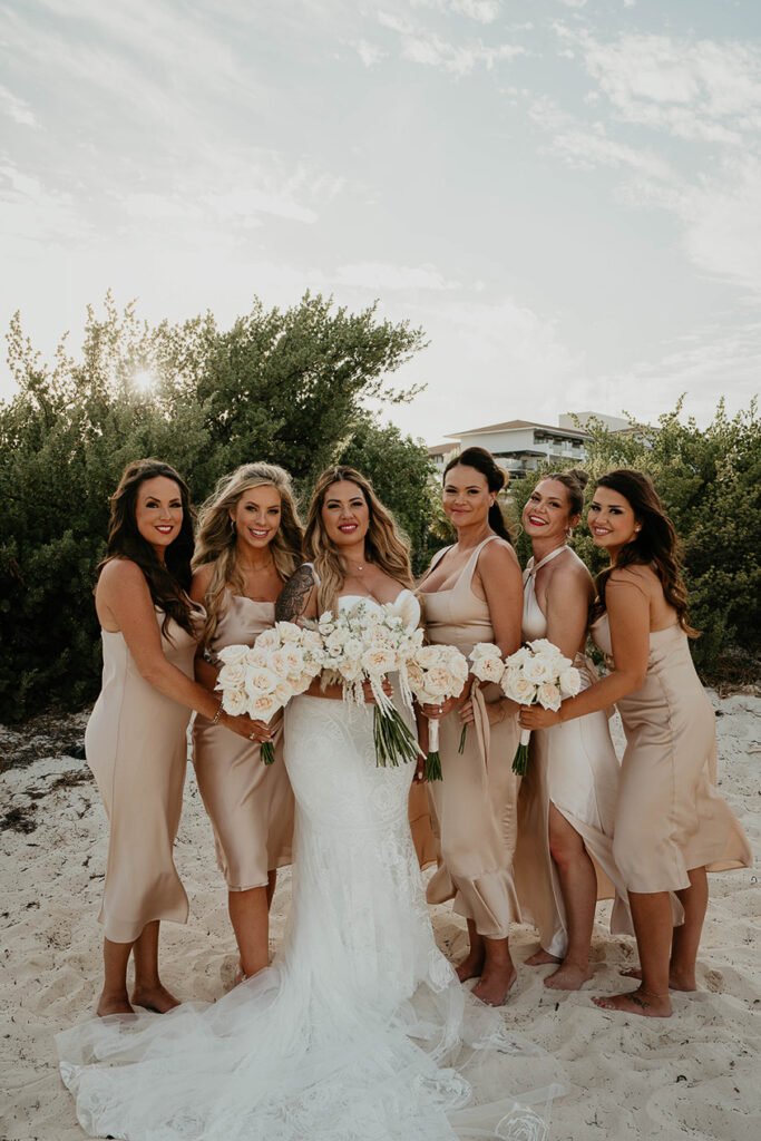 The bridesmaids and her brides on the beach during a Mexico destination wedding. 