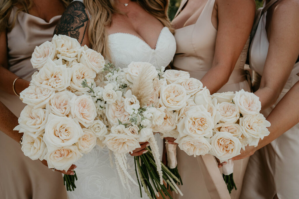 The bridesmaids holding white roses. 