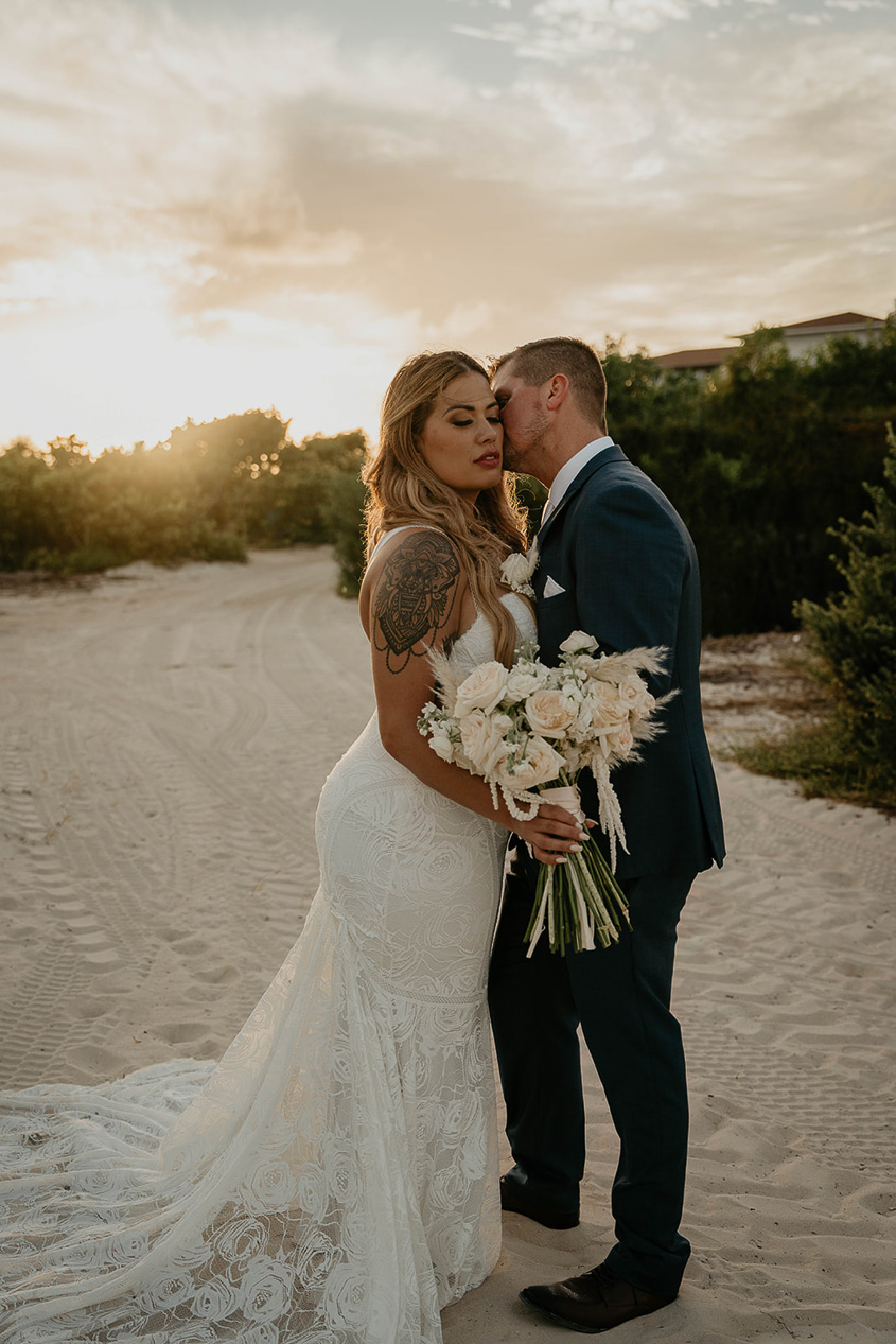 The bride and groom kissing at sunset during the Mexico destination wedding.