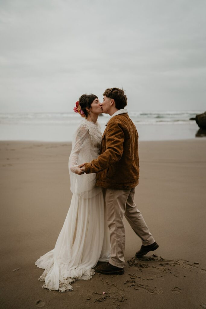 Bride and groom kiss on the beach while they elope on the Oregon Coast