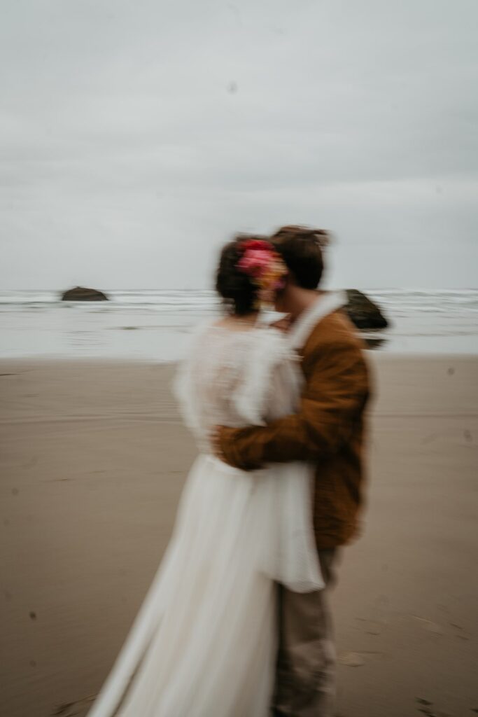 Bride and groom hug while they elopement on the beach in the pacific northwest