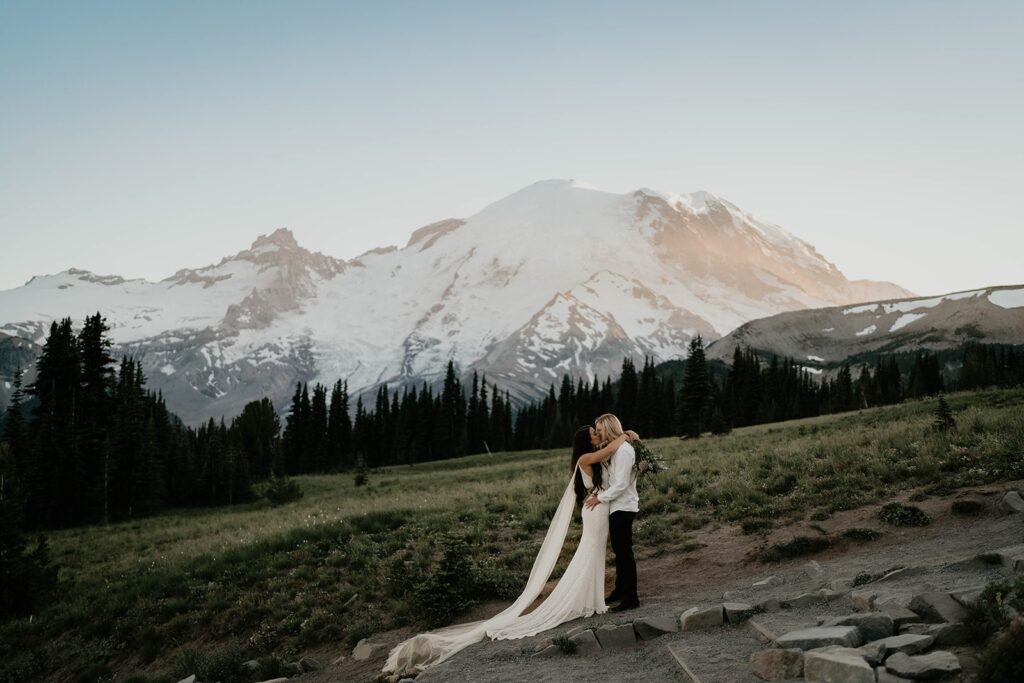 Two brides kiss in front of Mt Rainier during their elopement in the pacific northwest