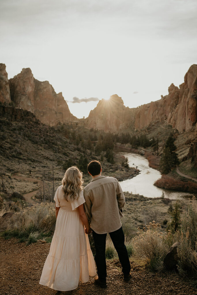 A couple holding hands taking in the iconic Smith Rock views. 