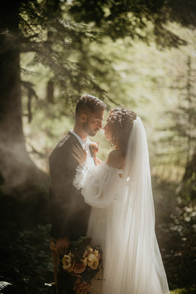 the newlyweds staring into each other's eyes under a pine tree. 