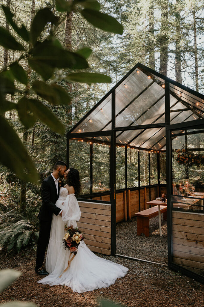 The newlyweds kissing outside the green house at The Woodlands house venue. 