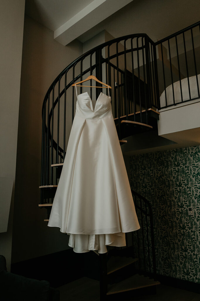 a wedding dress hung on a spiral staircase. 