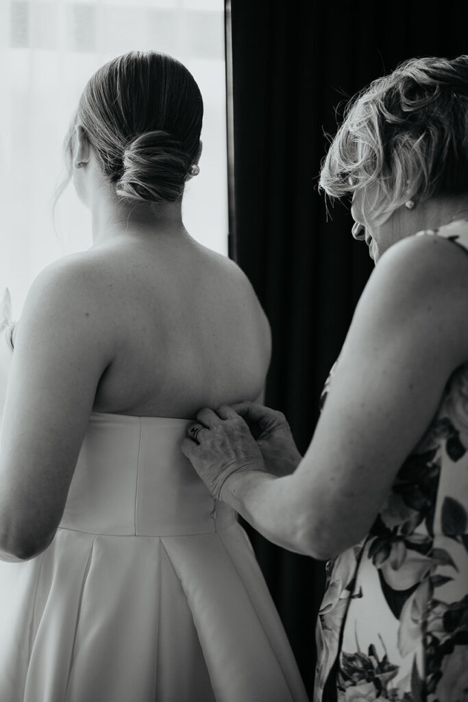 the bride putting on her wedding dress. 