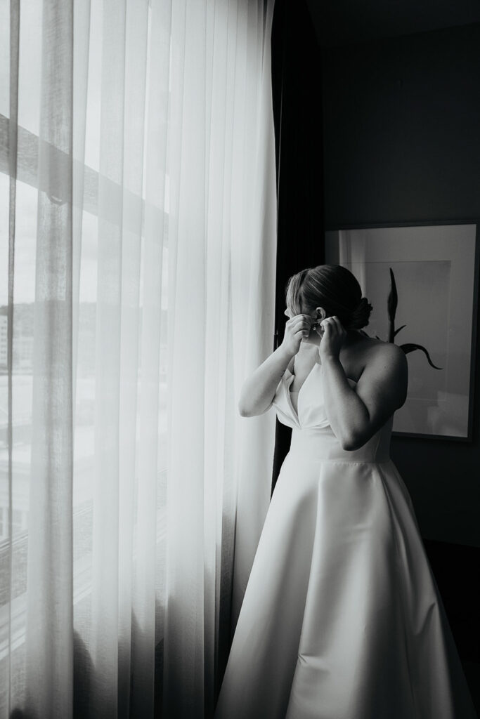 the bride putting on her earrings. 