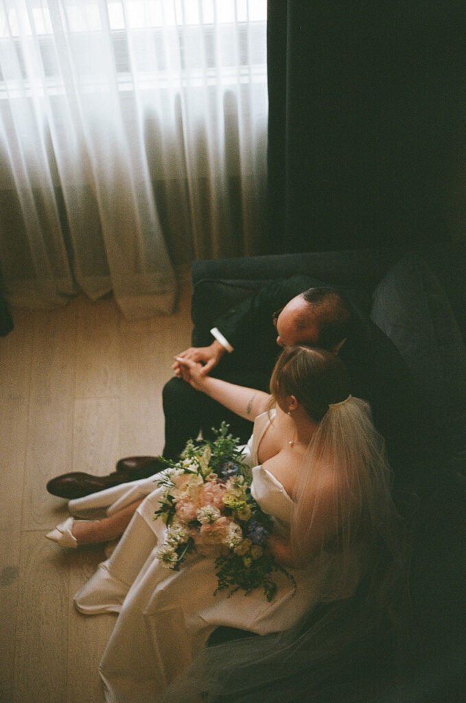 the bride and groom sitting and holding each other. 