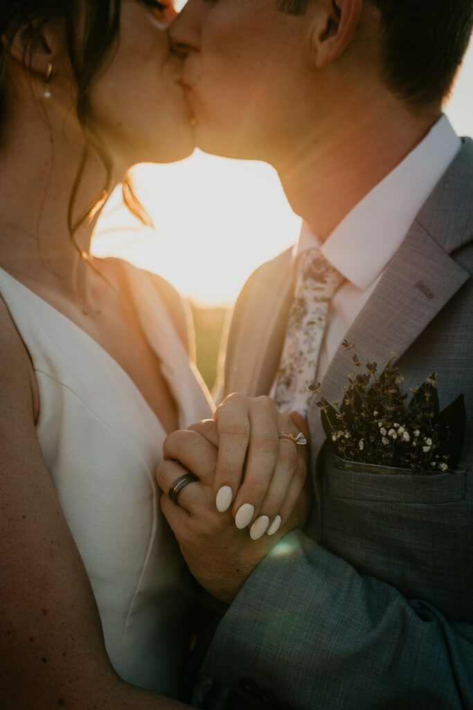 The newlyweds kissing at sunset. 