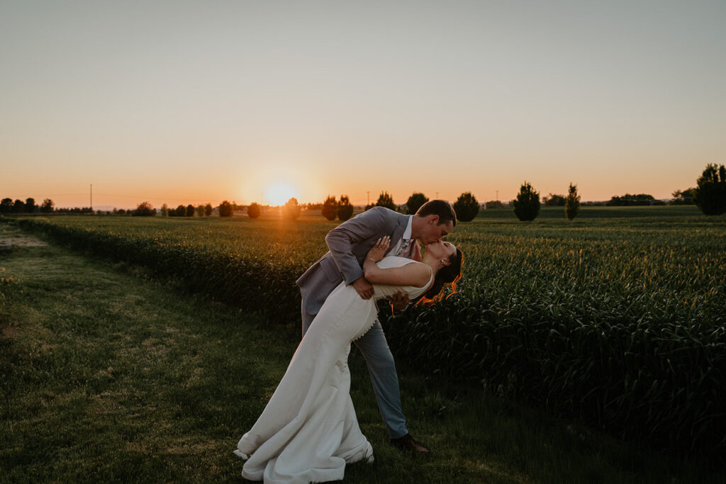 The newlyweds kissing with the sunset in the background at Dusted Valley. 