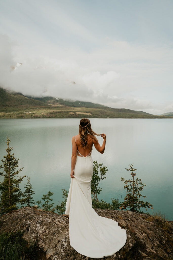 The bride looking out over the ocean and the mountains during her Alaska Elopement. 