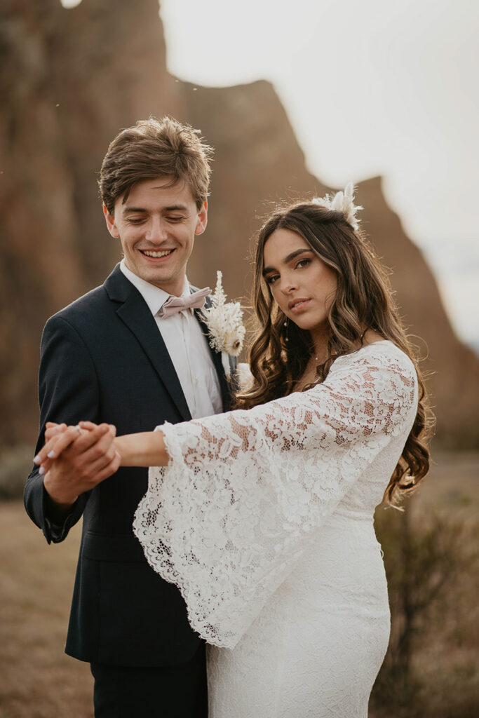 A couple holding hands and dancing in Smith Rock.